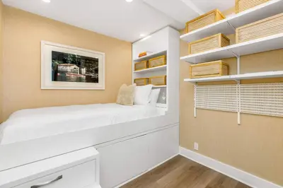 a bedroom with a white bed and shelves at Aquareve in Malibu Beach