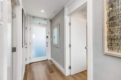 a hallway with white walls and an open door at Aquareve in Malibu Beach