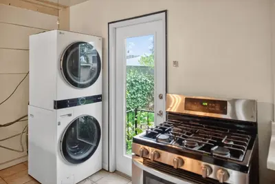 a kitchen with two washing machines next to a stove at Cozy Comfort Stylish 2BR 1BA near LAX, LMU, SoFi Stadium & Beaches in Los Angeles