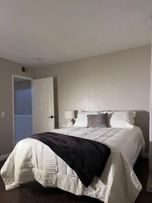a bedroom with a large bed with white sheets at Bright & Spacious 5BR Modern Vacation Home - Near Disneyland & Beaches in Orange