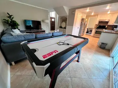 a ping pong table in a living room with a couch at Bright & Spacious 5BR Modern Vacation Home - Near Disneyland & Beaches in Orange
