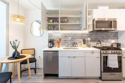 a kitchen with white cabinets and a sink and a stove at Boutique Mini 1 BD Residence in Los Angeles