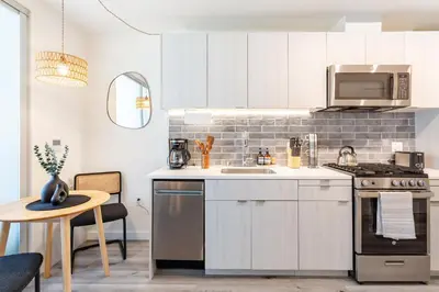 a kitchen with white cabinets and a sink and a microwave at Boutique Mini 1 BD Residence in Los Angeles