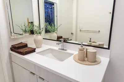 a white bathroom with a sink and a mirror at Boutique Mini 1 BD Residence in Los Angeles