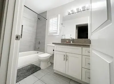 a white bathroom with a toilet and a tub and a sink at Normandie Good Vibes Only in Los Angeles