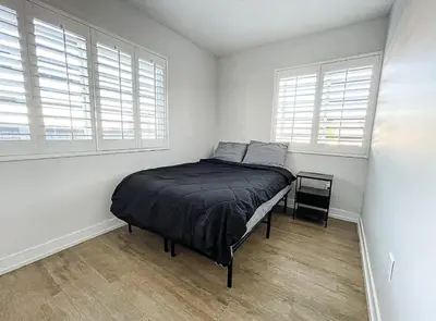 a bedroom with a bed in a room with windows at Normandie Good Vibes Only in Los Angeles