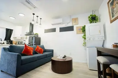 a living room with a blue couch and a kitchen at Modern Guesthouse ADU Sanctuary in San Bernardino