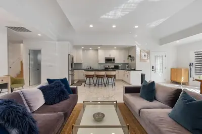 a living room with two couches and a kitchen at Minimalist Serene Home near Rose Bowl Stadium in Pasadena