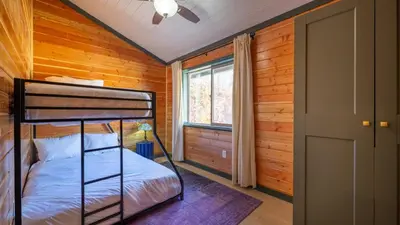 a bedroom with a bunk bed and a window at Arkouda Stays in Big Bear Lake