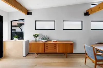 a living room with a wooden cabinet and a table at Brooks Beach House Your Venice Escape in Los Angeles
