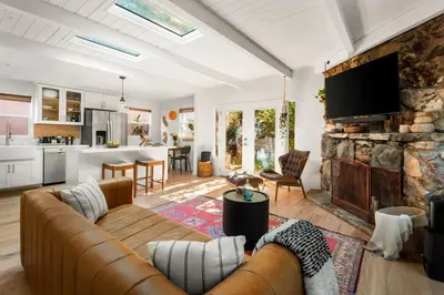 a living room with a couch and a stone wall at Laurel Canyon Hideaway Fireplace and Sauna in Los Angeles