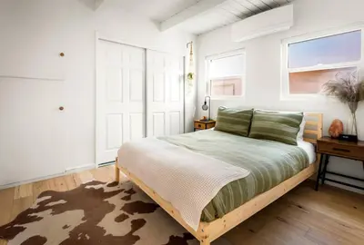 a bedroom with a bed and a table and windows at Laurel Canyon Hideaway Fireplace and Sauna in Los Angeles