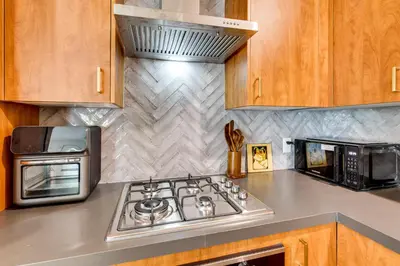 a kitchen with a stove and a microwave at 3 Mi to Old Pasadena Cozy Couples Studio with Pool in Pasadena