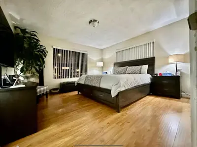 a bedroom with a large bed and a wooden floor at Proper Stays at Melrose - West Hollywood Premium E suite in Los Angeles