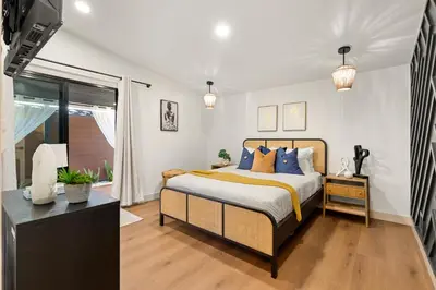 a bedroom with a bed with blue and orange pillows at Exclusive Disney Resort- Private Pool & Luxe Stay in Anaheim