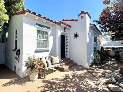 a white house with a bench in the front yard at Culver Adjacent Spanish in Los Angeles