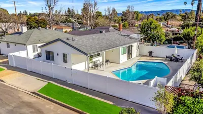 a home with a swimming pool and a white fence at Modern 3BR with King Bed, Gated Pool and BBQ Oasis in West Valley Area Heliport