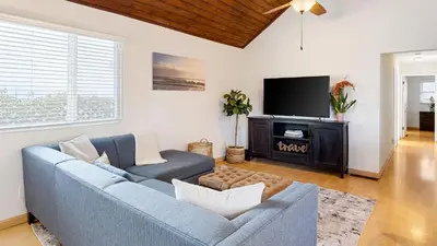 a living room with a blue couch and a tv at Sunny Venice Beach Home with Open Living Walkability to Abbot Kinney Venice Drift by AvantStay in Los Angeles