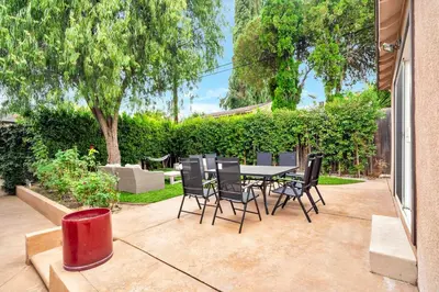 a patio with a table and chairs in a yard at Charming 3BR with Ping-Pong and Spa!