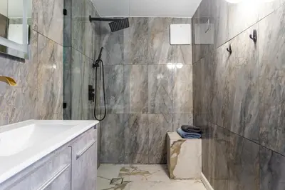 a bathroom with a shower and a tub and a sink at Hillside Home with Outdoor Oasis and Pool in Sherman Oaks