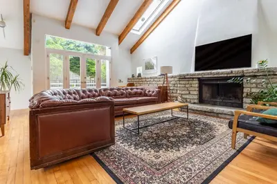 a living room with a leather couch and a fireplace at Hillside Home with Outdoor Oasis and Pool in Sherman Oaks