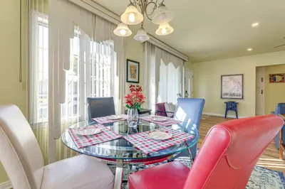 a dining room with a glass table and red chairs at Stylish Home Near SoFi Stadium, LAX and Long Beach in Compton