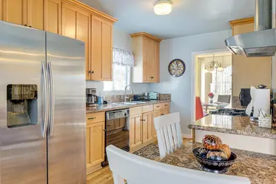 a kitchen with a stainless steel refrigerator and wooden cabinets at Stylish Home Near SoFi Stadium, LAX and Long Beach in Compton