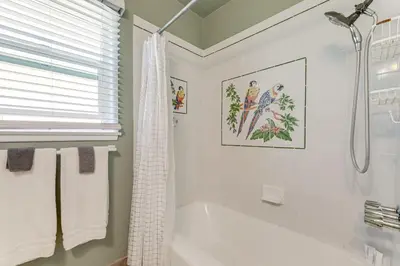 a white bathroom with a tub and a shower at Stylish Home Near SoFi Stadium, LAX and Long Beach in Compton