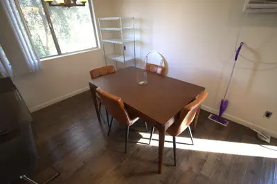 a dining room table with chairs and a vacuum at Charming 1-bedroom apartment in amazing Palms, Los Angeles with AC, Parking in Los Angeles