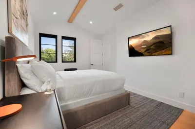 a white bedroom with a bed and a desk at Kraft Villa in Los Angeles