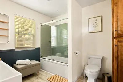 a bathroom with a tub and a toilet and a sink at Lumiere Cabin in Lake Arrowhead