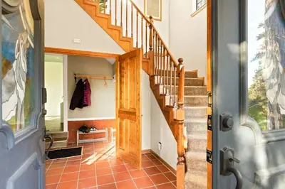 a hallway with a wooden staircase in a home at Lumiere Cabin in Lake Arrowhead
