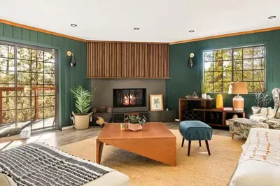 a living room with green walls and a fireplace at Lumiere Cabin in Lake Arrowhead