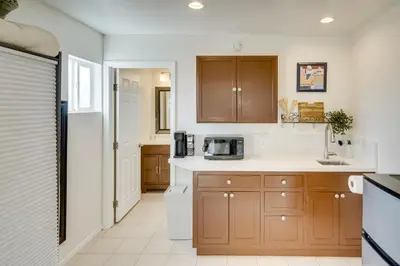 a kitchen with wooden cabinets and a microwave at Work and Play! Extended-Stay Studio in Simi Valley in Simi Valley