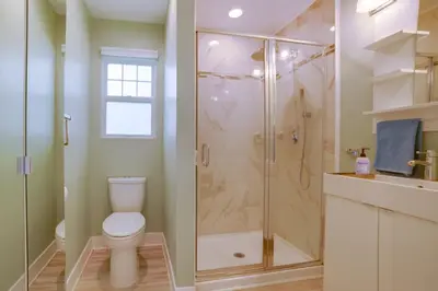 a bathroom with a shower with a toilet and a sink at Walk to Festival of Lights Cozy Couples Retreat in Riverside