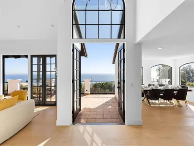 a living room with a table and a view of the ocean at Villa Costera in Malibu Beach