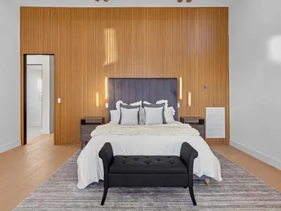 a bedroom with a large bed and a black couch at Villa Costera in Malibu Beach