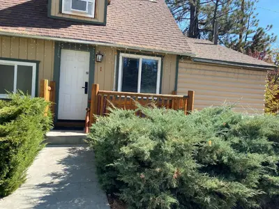 a house with a wooden gate and some bushes at Bear Creek Resort in Big Bear Lake
