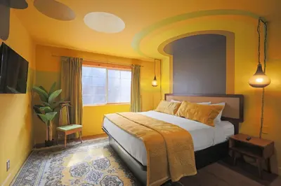 a bedroom with a bed with yellow walls at Sessions Retreat & Hotel in Big Bear Lake