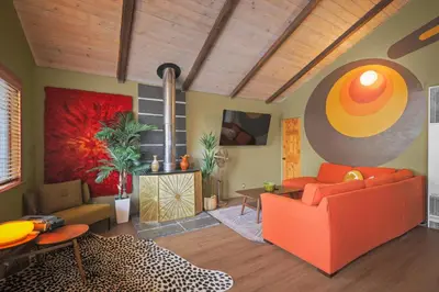 a living room with a orange couch and a table at Sessions Retreat & Hotel in Big Bear Lake