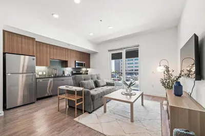 a living room with a couch and a kitchen at Stylish Condo Mins to Shoreline in Long Beach