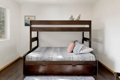 a wooden bunk bed with pillows on it in a room at View On the Rocks Scenic Mountain Oasis with Hot Tub, Fire Pit and Game Room in Big Bear Lake