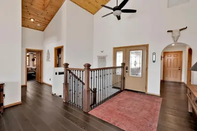 a living room with a staircase and a ceiling fan at View On the Rocks Scenic Mountain Oasis with Hot Tub, Fire Pit and Game Room in Big Bear Lake