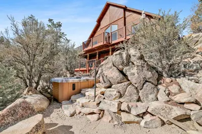 a house on the side of a mountain with rocks at View On the Rocks Scenic Mountain Oasis with Hot Tub, Fire Pit and Game Room in Big Bear Lake