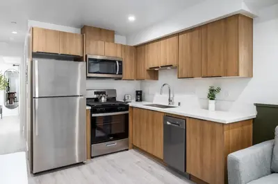 a kitchen with stainless steel appliances and wooden cabinets at Cozy LA Getaway Fast Wi-Fi and Smart TV in Los Angeles