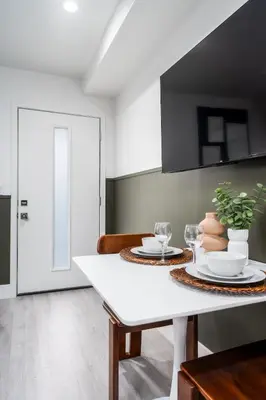 a dining room with a white table with plates and glasses at Cozy LA Getaway Fast Wi-Fi and Smart TV in Los Angeles