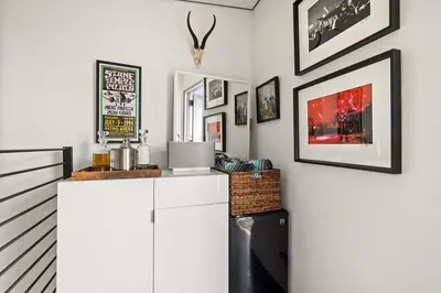 a kitchen with white cabinets and pictures on the wall at Hip Venice 5BR 4BA Home w Rooftop and Steps to the Beach in Los Angeles