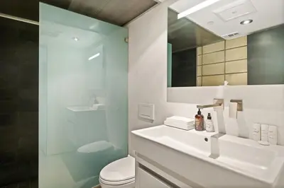 a bathroom with a sink and a toilet and a mirror at Hip Venice 5BR 4BA Home w Rooftop and Steps to the Beach in Los Angeles