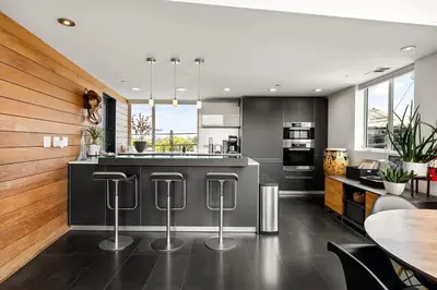 a kitchen with black and white counters and a table at Hip Venice 5BR 4BA Home w Rooftop and Steps to the Beach in Los Angeles