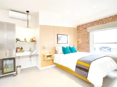 a bedroom with a large bed and a brick wall at Venice V Hotel in Los Angeles
